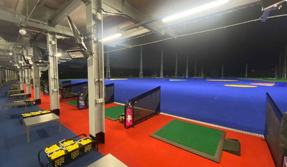 Covered hitting bays overlooking the illuminated Good Time Golfin range at night
